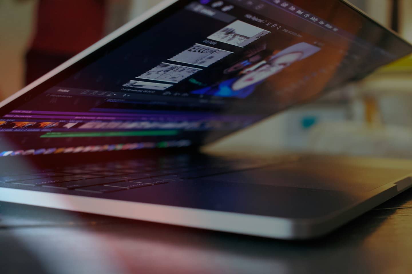 Silver laptop open with video editing software on screen.