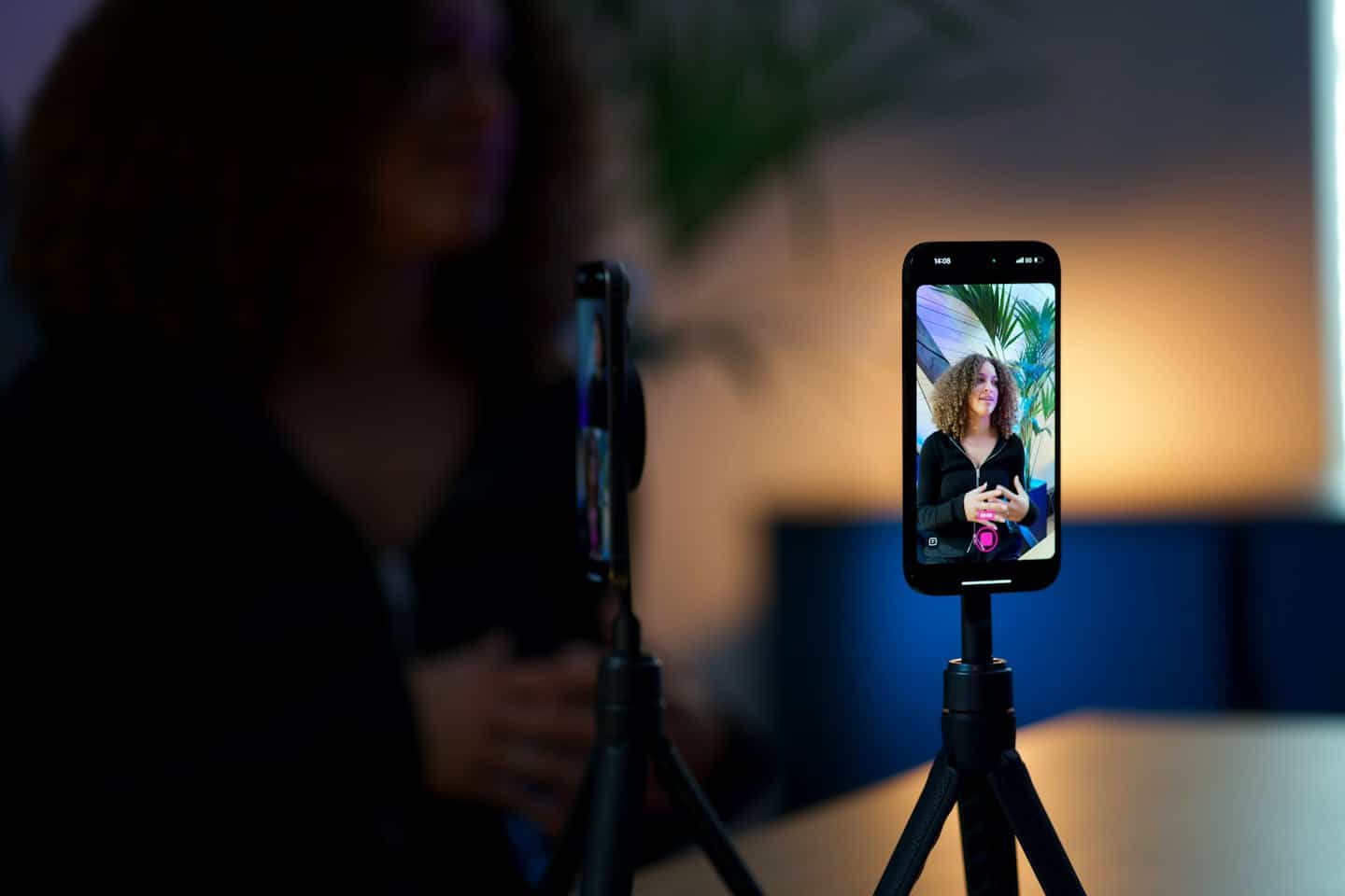 Smartphone on a tripod recording a woman presenting for video.